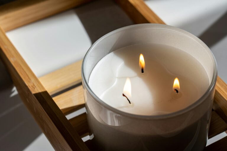 Elegant three-wick candle with a warm glow on a wooden tray, perfect for a tranquil ambiance.