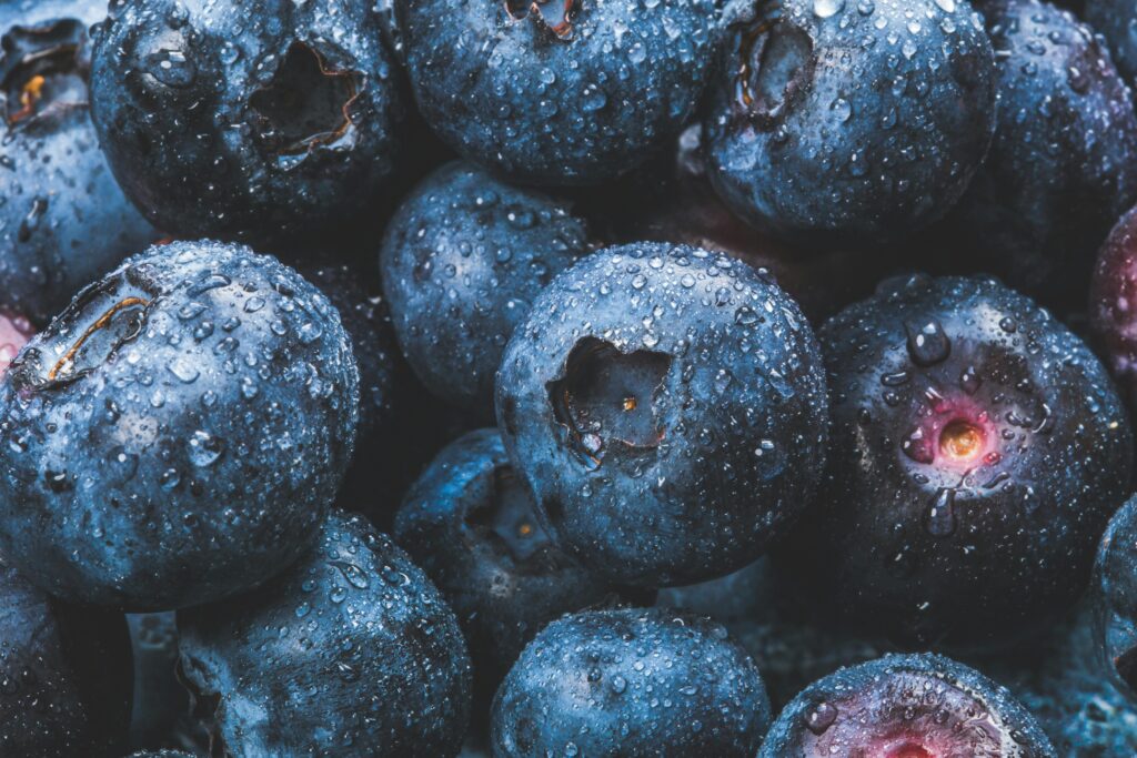 Fresh blueberries covered with water droplets, showcasing their juiciness and vibrant blue color. Perfect for healthy eating concepts.