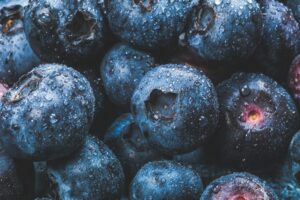 Fresh blueberries covered with water droplets, showcasing their juiciness and vibrant blue color. Perfect for healthy eating concepts.
