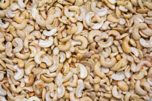 A detailed close-up of roasted cashew nuts creating a textured, appetizing backdrop.